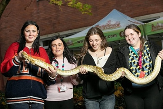 Students with one of the snakes from Kidz Farm