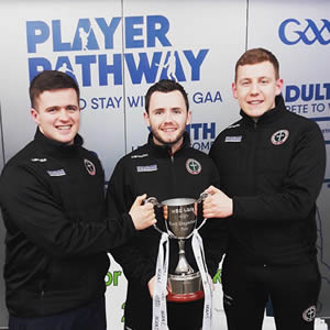 Ladies gaelic football team managers and coach holding the Gourmet Food Parlour Moynihan Cup 